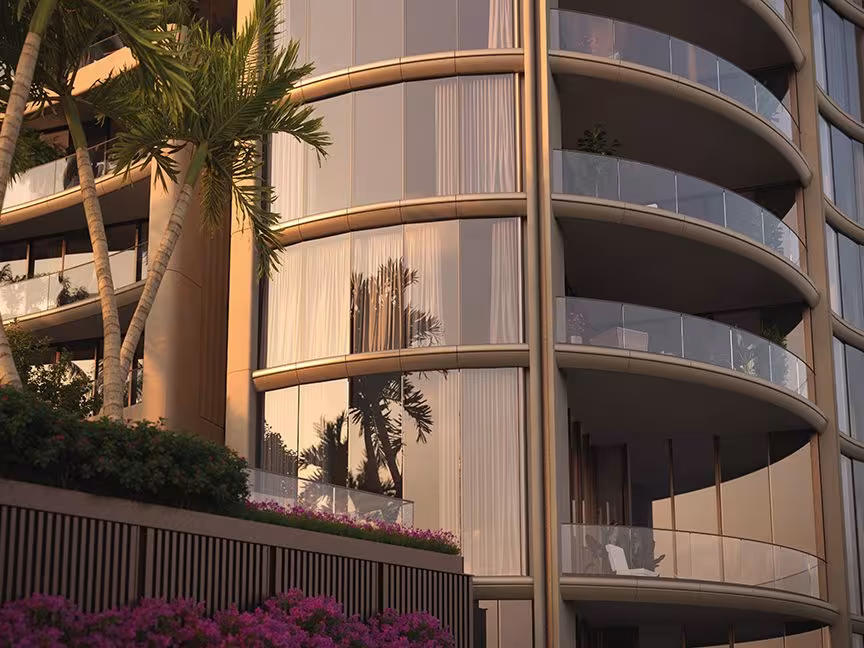 Curved tower balconies framed by palms at sunset