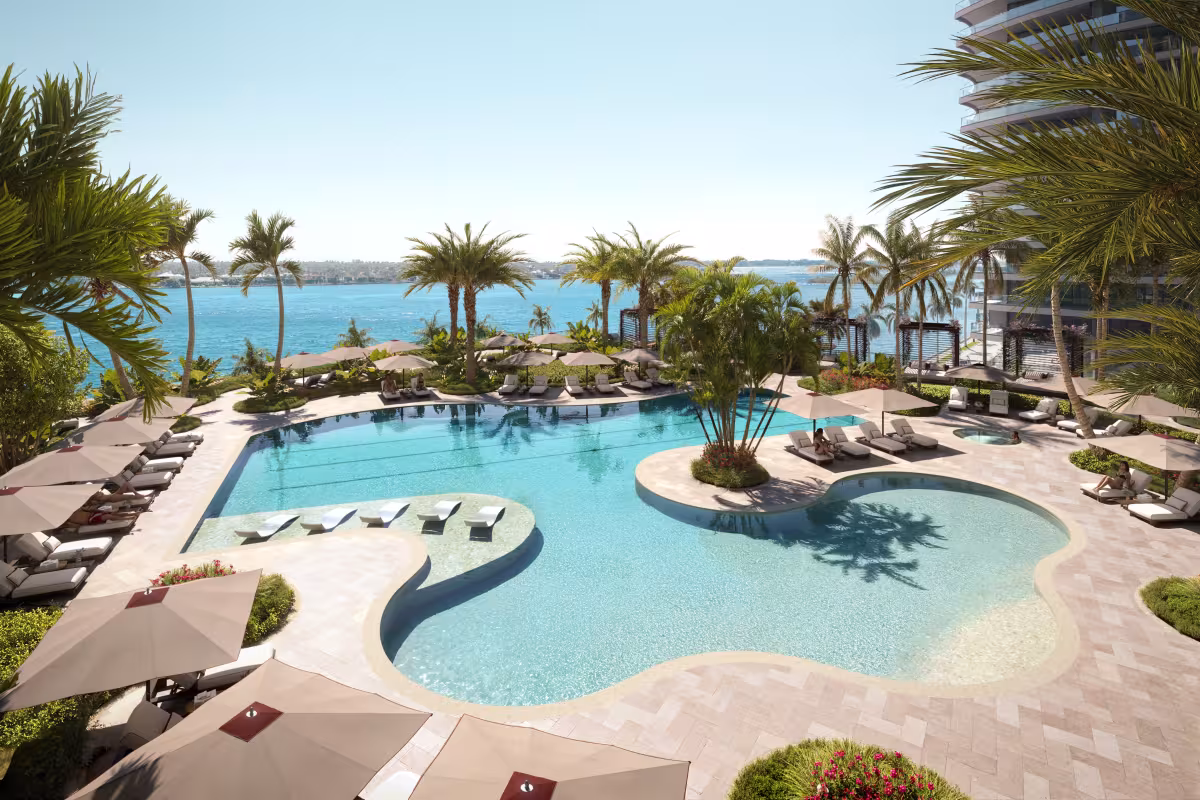 The vitality pool, surrounded by palms and loungers, looking out to the water
