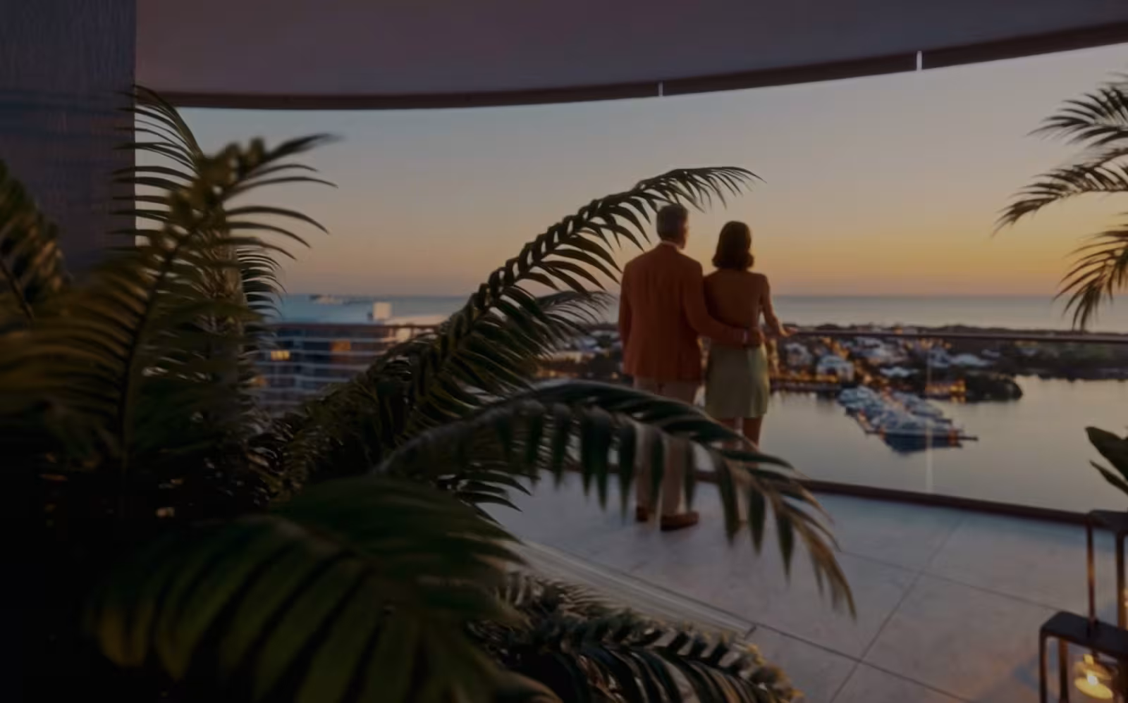 Couple on a terrace overlooking the water at sunset